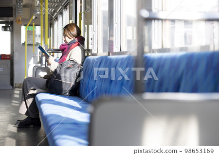 坐在火車上看書的中年婦女 98653169
