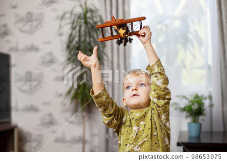 Happy child boy plays with toy airplane and dreams of becoming a pilot Happy child boy plays with toy airplane and dreams of becoming a pilot 98653975