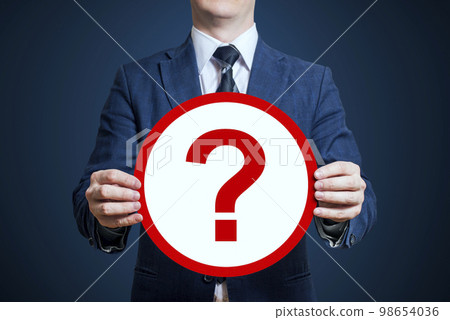 Businessman holding a poster 'question mark' 98654036