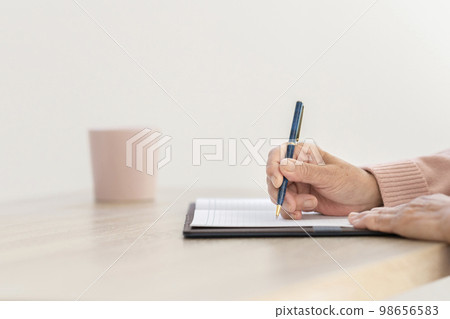 拿著筆的一位資深婦女的手 98656583