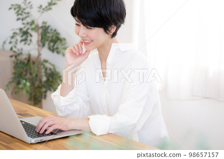 一位在休閒辦公室工作的漂亮女人,前面有綠色模糊 一位在休閒辦公室工作的漂亮女人,前面有綠色模糊 98657157