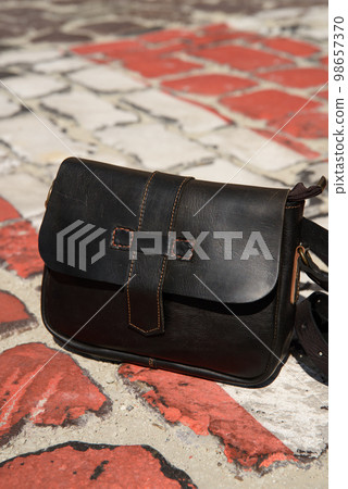 close-up photo of brown small craft leather bag on a crosswalk close-up photo of brown small craft leather bag on a crosswalk 98657370