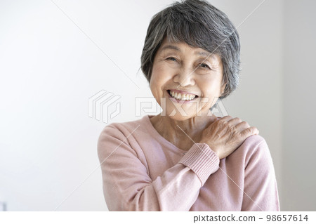 Senior woman looking at camera and smiling Senior woman looking at camera and smiling 98657614