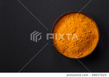Bright yellow turmeric or curry spice for Asian food preparation Bright yellow turmeric or curry spice for Asian food preparation 98657829