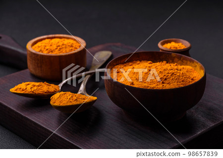 Bright yellow turmeric or curry spice for Asian food preparation 98657839
