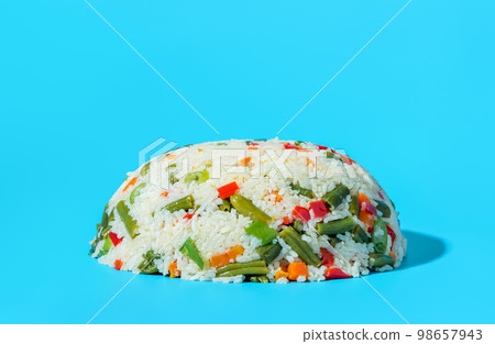 Vegan dish, white rice with a mix of vegetables isolated on a blue background 98657943