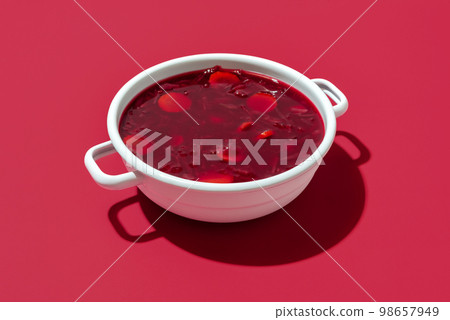 Red beet soup bowl on a red background. Bowl of the Ukrainian borscht. 98657949