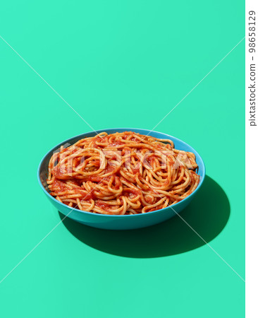 Spaghetti Pomodoro dish isolated on a green background Spaghetti Pomodoro dish isolated on a green background 98658129