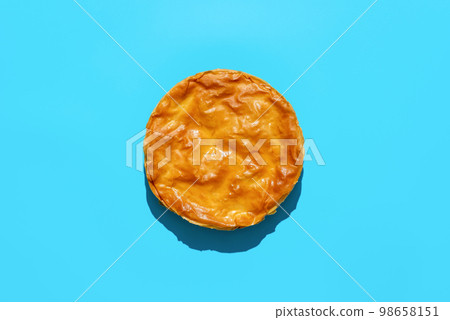Phyllo dough cake with spinach and cheese, above view on a blue background Phyllo dough cake with spinach and cheese, above view on a blue background 98658151