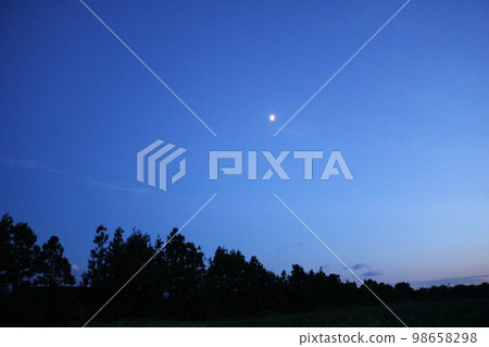 moon floating in the night sky 98658298