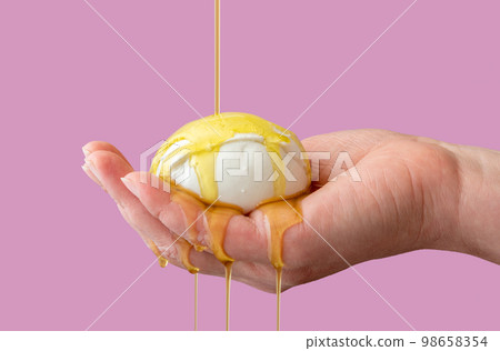 Mozzarella cheese with olive oil in woman hand. Pouring olive oil over mozzarella ball Mozzarella cheese with olive oil in woman hand. Pouring olive oil over mozzarella ball 98658354