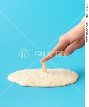 Sourdough starter isolated on blue background. Testing the yeast 98658372