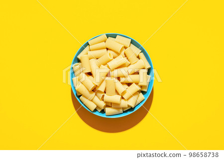 Rigatoni pasta top view on a yellow background Rigatoni pasta top view on a yellow background 98658738
