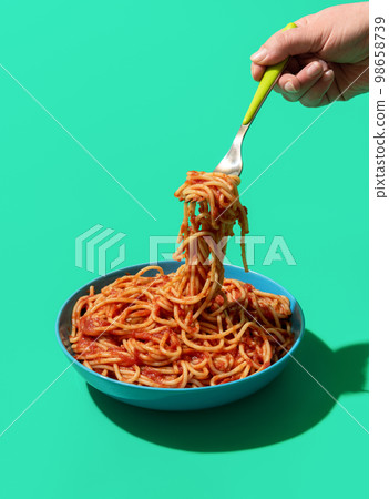 Spaghetti Pomodoro on a fork, minimalist on a green background Spaghetti Pomodoro on a fork, minimalist on a green background 98658739