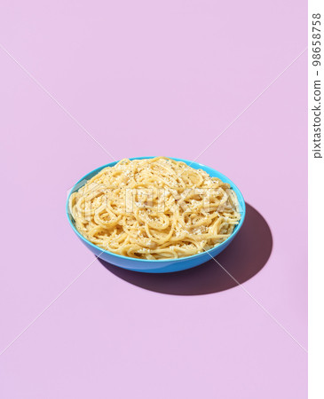 Spaghetti cacio e pepe in a bowl on a purple background Spaghetti cacio e pepe in a bowl on a purple background 98658758