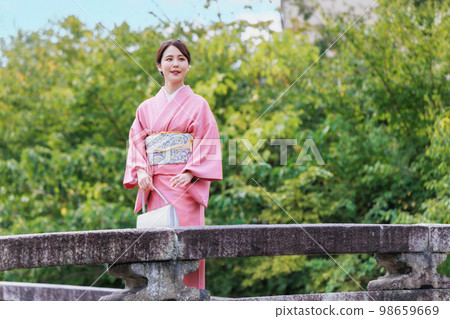 Kyoto sightseeing, a woman in a kimono crossing the Shirakawa Furumonmae Bridge Kyoto sightseeing, a woman in a kimono crossing the Shirakawa Furumonmae Bridge 98659669