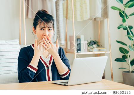 Surprised young woman with a computer Surprised young woman with a computer 98660155