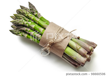 An edible, raw stems of asparagus isolated on white background. An edible, raw stems of asparagus isolated on white background. 98660506