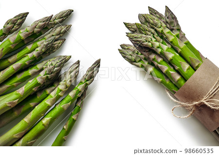 An edible, raw stems of asparagus isolated on white background. An edible, raw stems of asparagus isolated on white background. 98660535