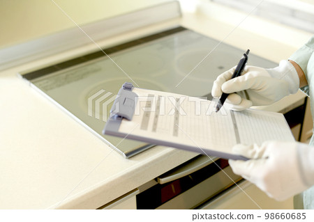 檢查廚房 IH 爐子的男性工人的手 98660685