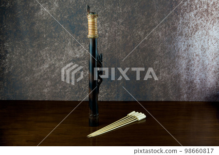Small Blowpipe and Darts Made by the Dayak People of Sarawak in Borneo on an Old Varnished Table Top Small Blowpipe and Darts Made by the Dayak People of Sarawak in Borneo on an Old Varnished Table Top 98660817