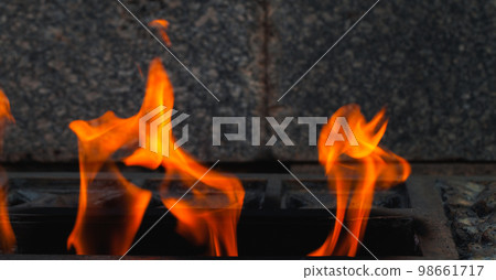 Eternal flame burns on dark stones background 98661717