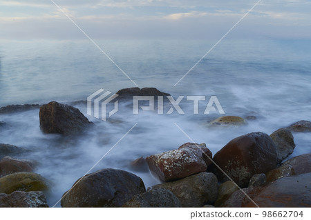 Rocky beach at sunrise, colors 98662704