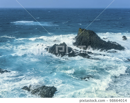 波浪在礁石上擊敗 98664014
