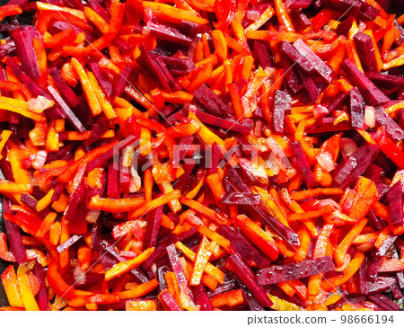 Cooking healthy food from vegetables. Chopped carrots with beetroot in a frying pan. 98666194