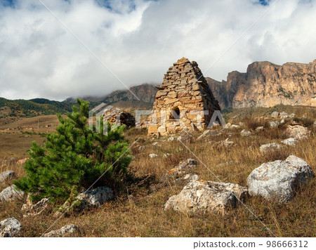 Old stone tomb, a crypt on the top of a mountain. Old Ossetian family crypt in the misty mountains. Russia. Old stone tomb, a crypt on the top of a mountain. Old Ossetian family crypt in the misty mountains. Russia. 98666312