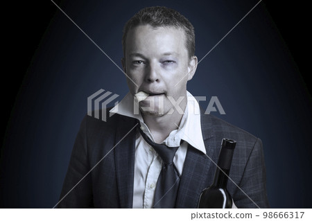 Businessman in suit drinking alcohol from a bottle. Toned 98666317