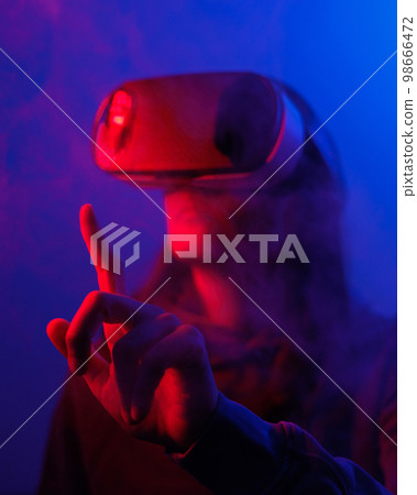 person wearing virtual reality glasses gets experience of gaming and entertainment person wearing virtual reality glasses gets experience of gaming and entertainment 98666472