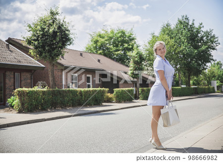 Attractive blonde in dress on a cozy green street in Skals Denmark Attractive blonde in dress on a cozy green street in Skals Denmark 98666982