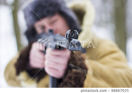 Retro photo of a soldier in the winter forest. Focus on the weapon 98667035