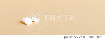 Heap of white pills on colored background. Tablets scattered on a table. Pile of red soft gelatin capsule. Vitamins and dietary supplements concept 98667075