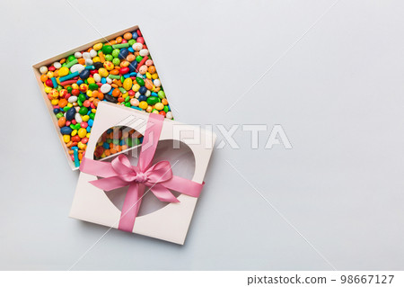 Box with sweet chocolate candies on color background, Various candy sweets. Valentines day gift box. Top view flat lay with copy space 98667127
