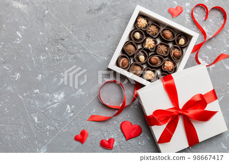 Delicious chocolate pralines in red box for Valentine's Day. Heart shaped box of chocolates top view with copy space 98667417