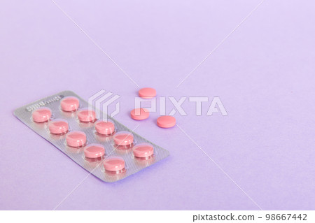 Blister package with Vitamin on color background. Medicine pills on a light background. Medicines and prescription pills flat lay background. pink medical tablets in blister 98667442