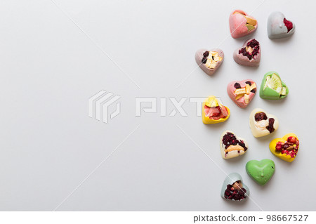 chocolate sweets in the form of a heart with fruits and nuts on a colored background. top view with space for text, holiday concept 98667527