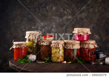 Pickled vegetables in glass jars. 98668079