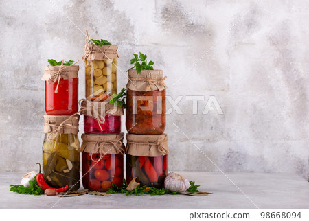 Pickled vegetables in glass jars. 98668094