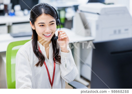 在呼叫中心工作的年輕女子 在呼叫中心工作的年輕女子 98668288