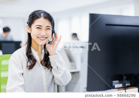 在呼叫中心工作的年輕女子 在呼叫中心工作的年輕女子 98668290