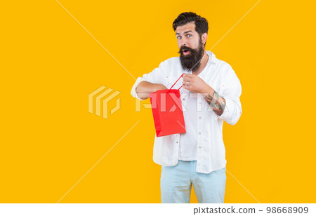 good discount for shocked man isolated on yellow. shopping man hold discount purchase. 98668909