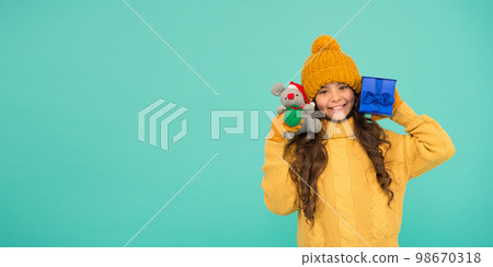 Shopping tips. Rat symbol of year. Happy girl hold mouse toy and wrapped gift box. Kid knitted sweater and hat play plush toy. Shop for kids. Happy 2020 year. Gift for good luck. Appease with gift Shopping tips. Rat symbol of year. Happy girl hold mouse toy and wrapped gift box. Kid knitted sweater and hat play plush toy. Shop for kids. Happy 2020 year. Gift for good luck. Appease with gift 98670318