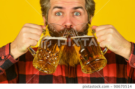 Brutal bearded male drinks beer from glass. Beer pub. Stylish bartender or barman in bar. recreation. Man hold glass of beer. hipster at bar counter. having fun watching football Brutal bearded male drinks beer from glass. Beer pub. Stylish bartender or barman in bar. recreation. Man hold glass of beer. hipster at bar counter. having fun watching football 98670514