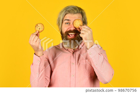 Sweet cookies. Sweet Tooth concept. Cookies on his mind. Bearded man hold cookies on eyes. Yummy delicious treats. Obsessed with pastry. Recipe homemade cookies. Happy hipster eat cookie dessert 98670756
