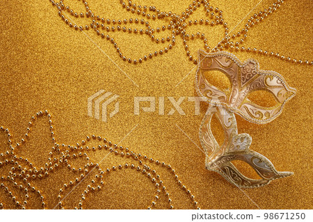 Mardi gras or carnival mask with beads on gold glowing background. Venetian mask. Mardi gras or carnival mask with beads on gold glowing background. Venetian mask. 98671250