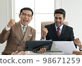 Close up of  happy success group of businesspeople during presentation. Colleagues cheering and smiling. 98671259