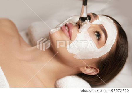 Young beautiful woman with facial mask, spa treatment 98672760